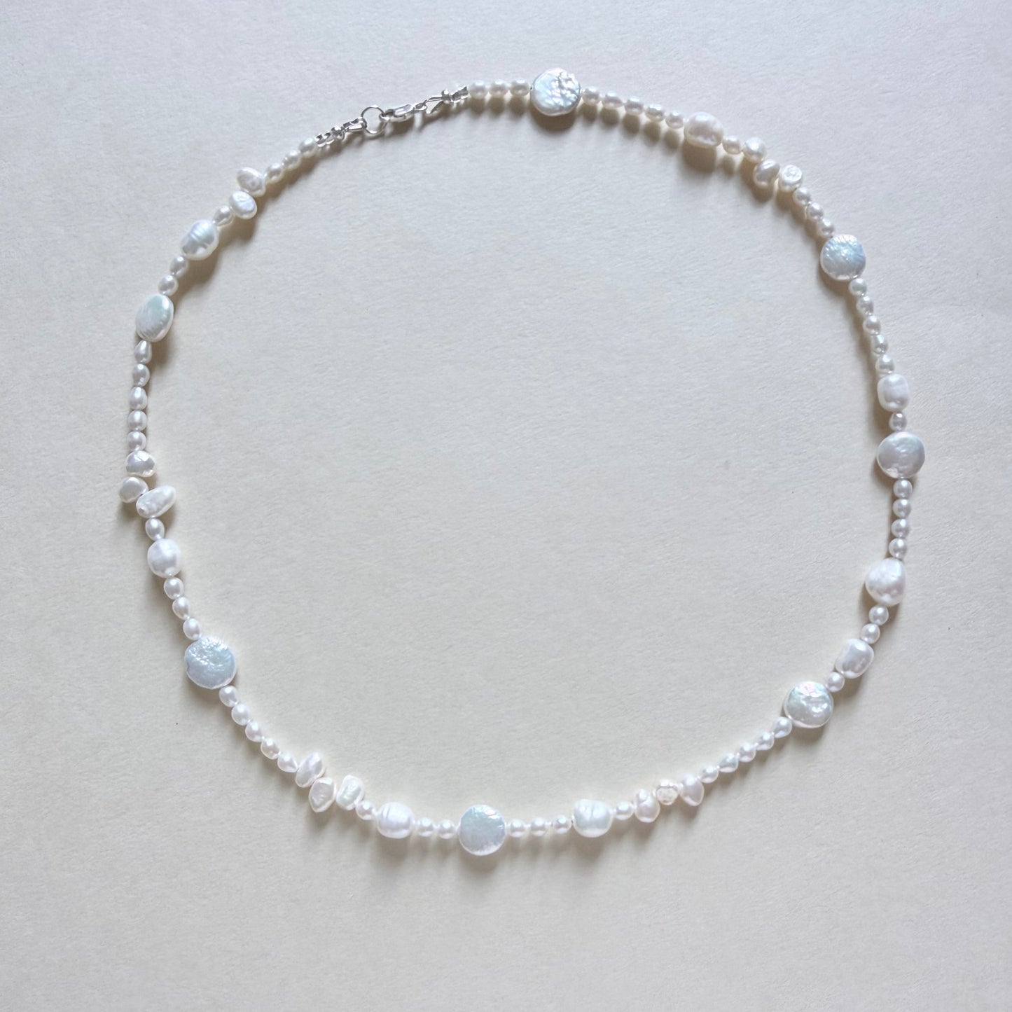 Pearl necklace on a light gray background