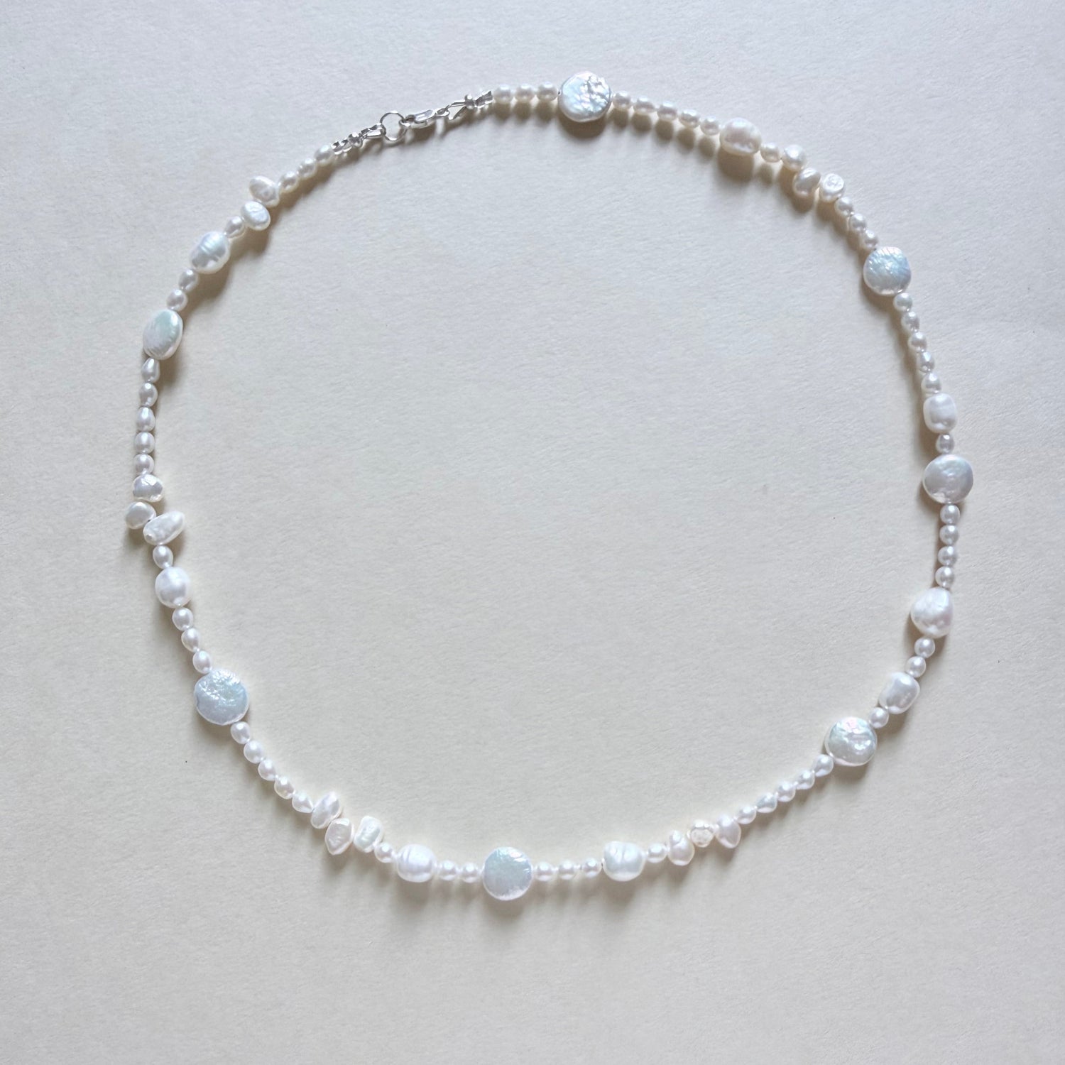 Pearl necklace on a light gray background