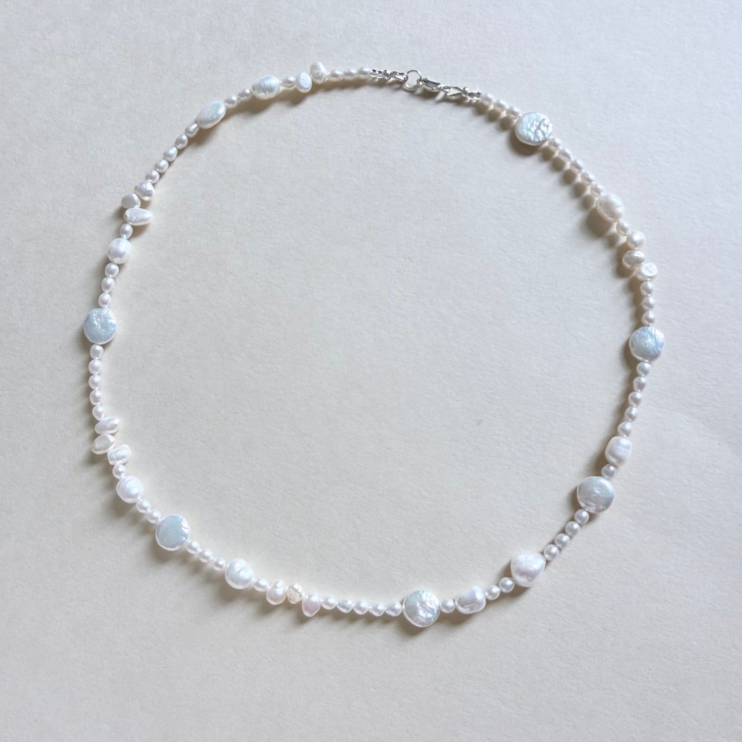 Pearl necklace on a light beige background