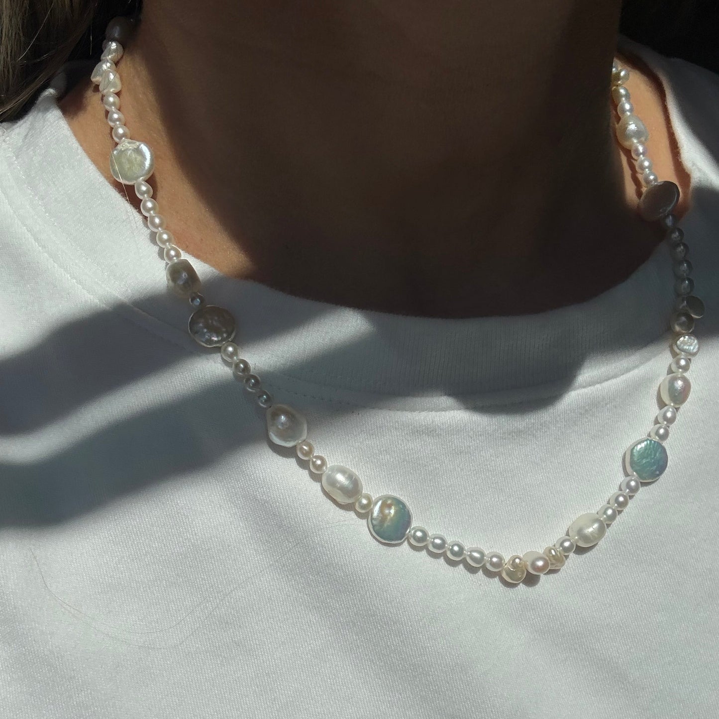 Pearl necklace with opal stones on a white background