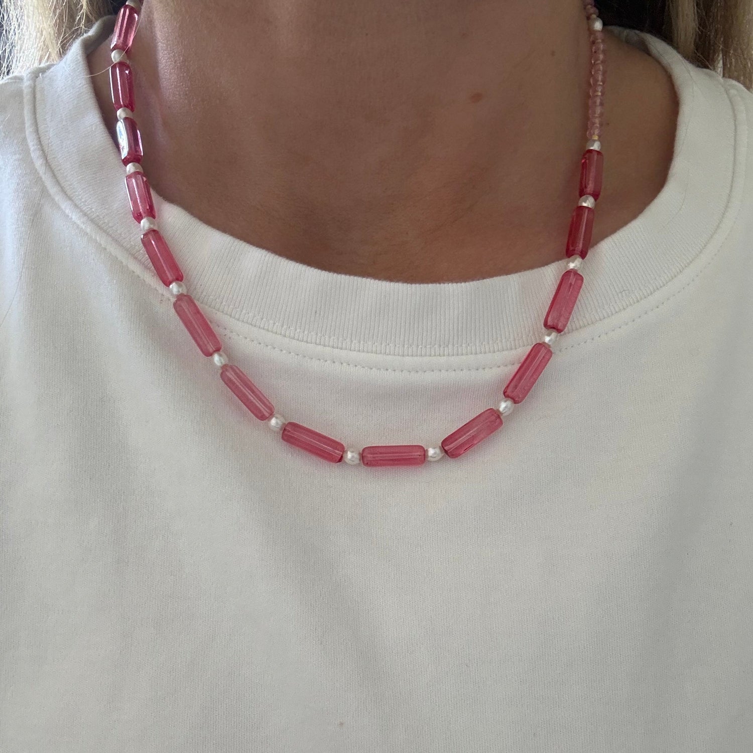 Close-up of a pink beaded necklace on a plain background
