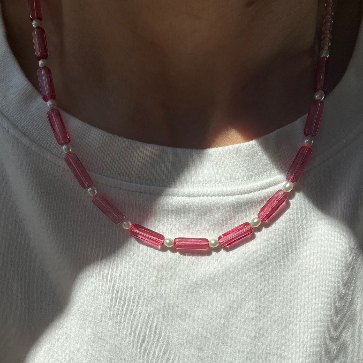 Close-up of a beaded necklace on a white shirt