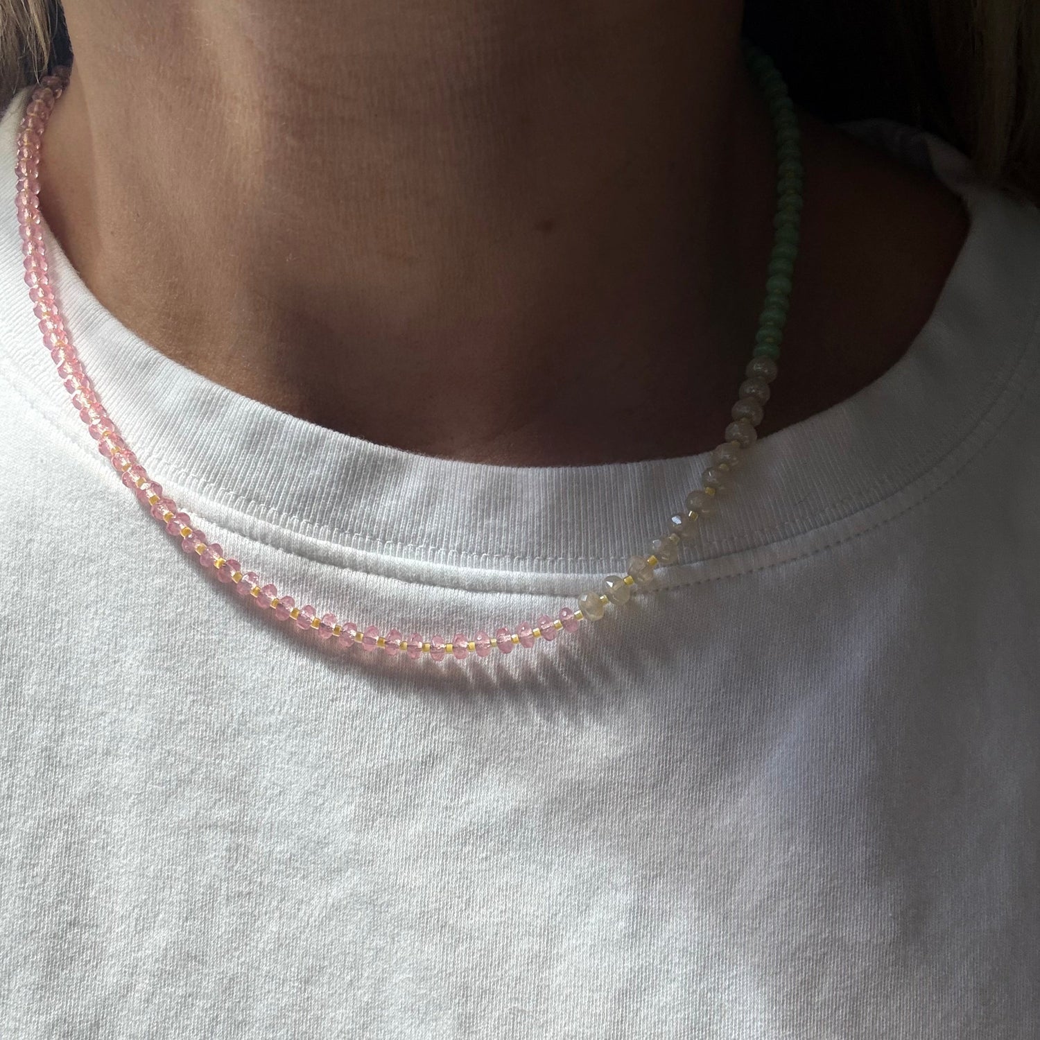 Close-up of a white shirt with pink trim on a plain background