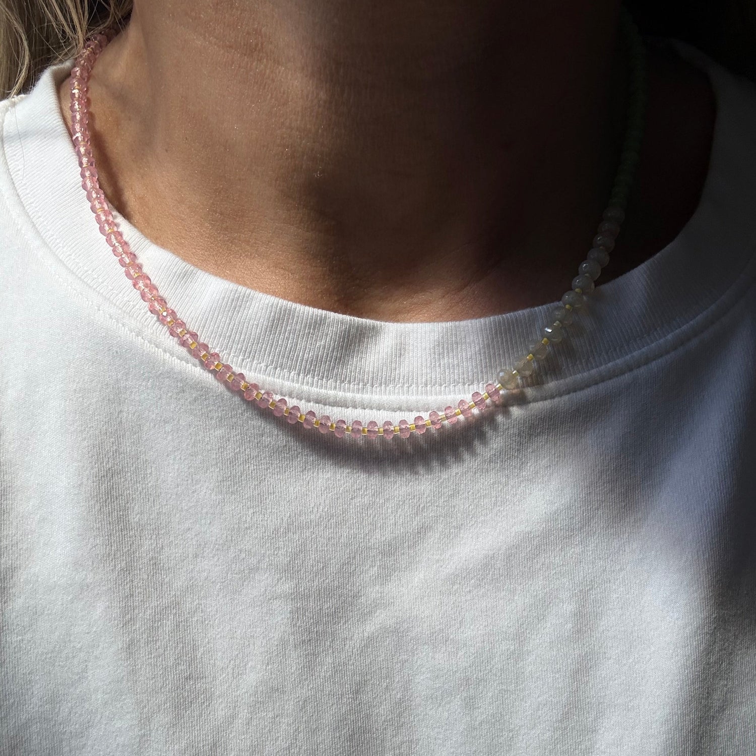 Close-up of a white garment with pink trim on a plain background
