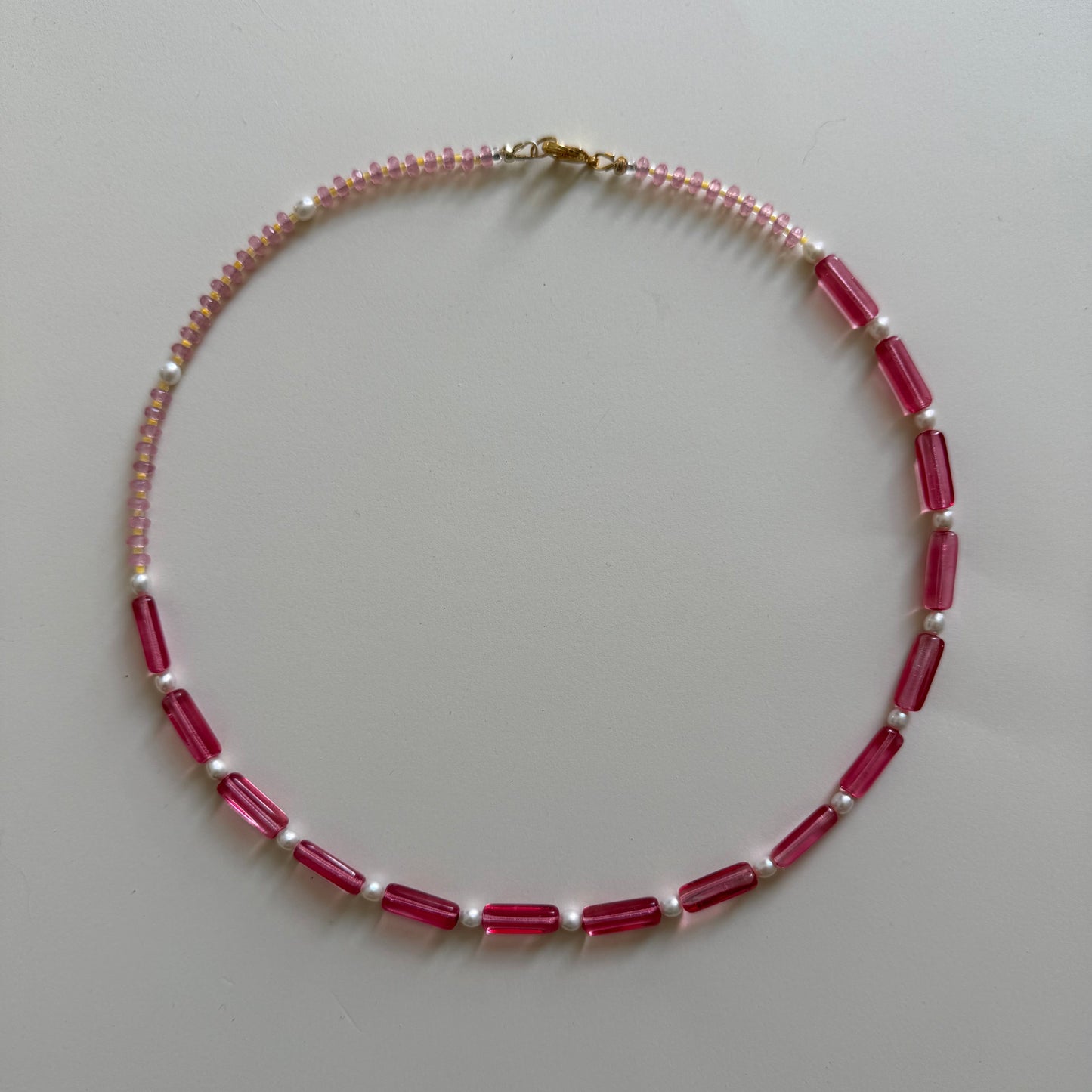 Necklace with red and white beads on a light gray background