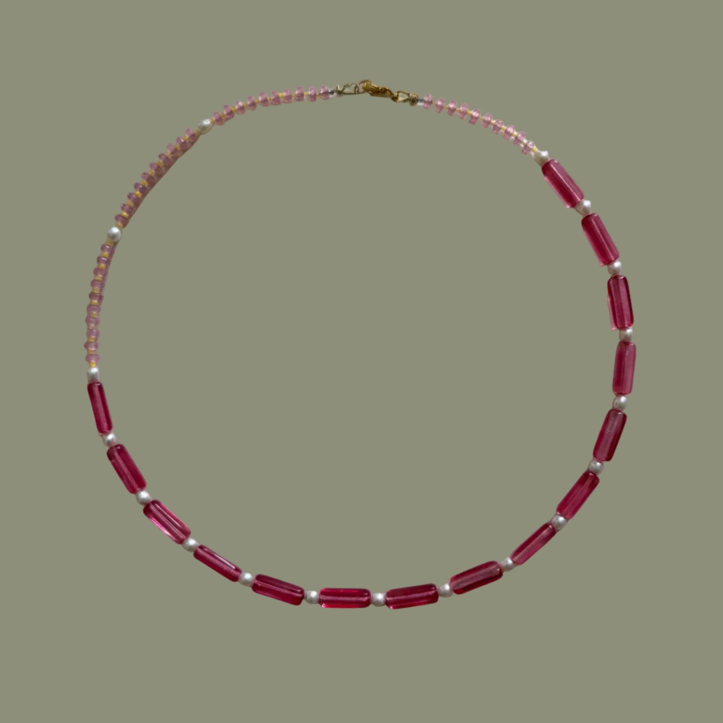 Necklace with red and white beads on a light gray background