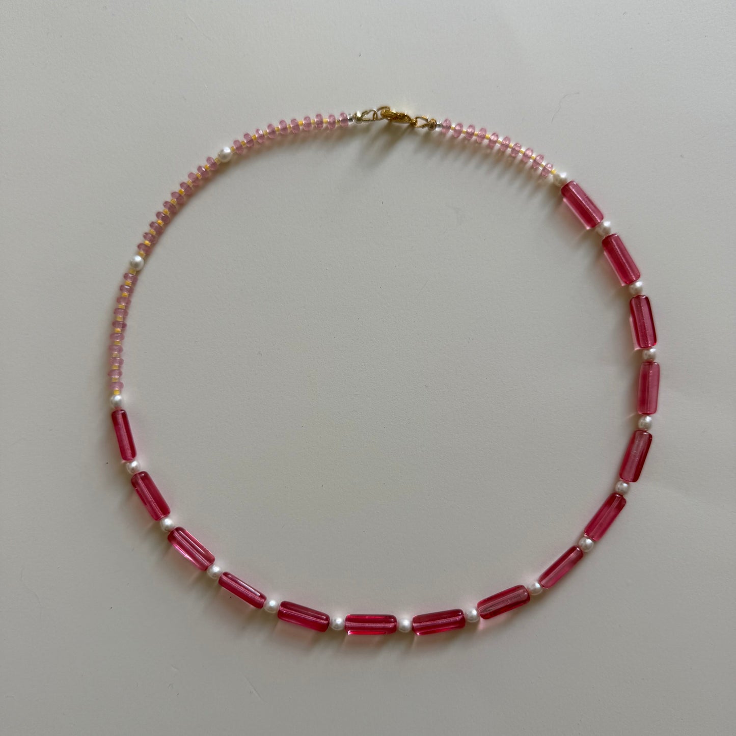 Necklace with red and white beads on a light gray background