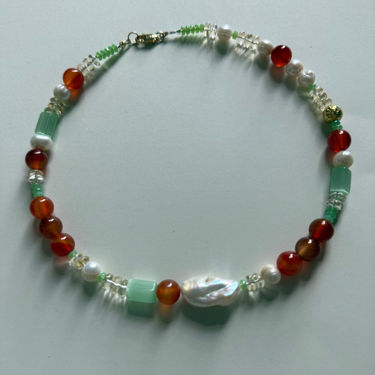 Necklace with multicolored beads on a light gray background