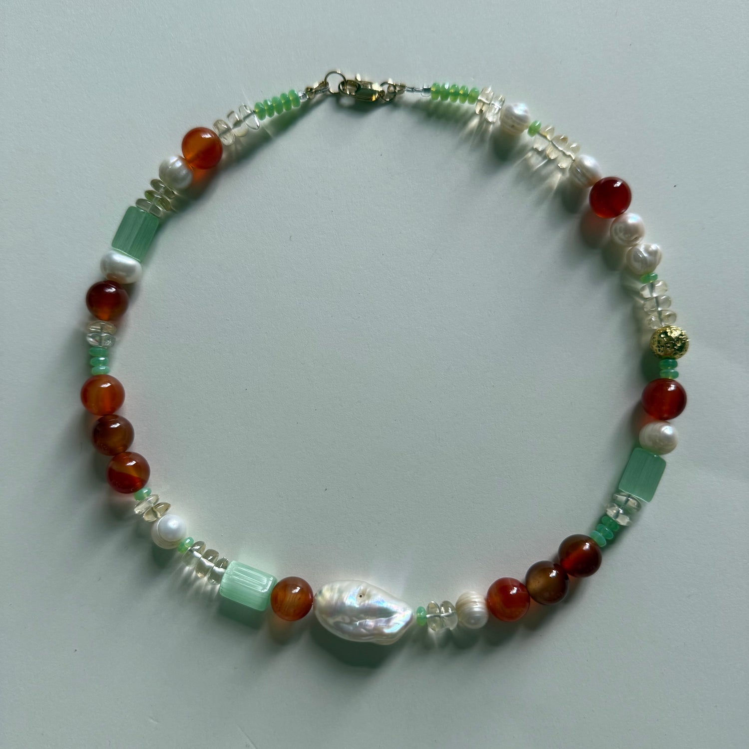 Beaded bracelet with multicolored beads on a light gray background