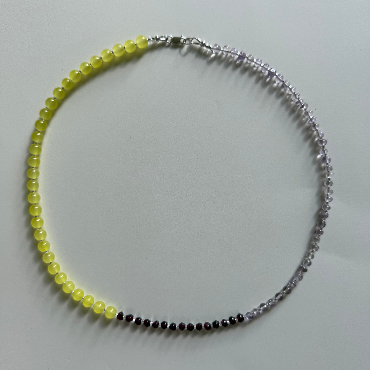 Necklace with yellow, black, and silver beads on a white background