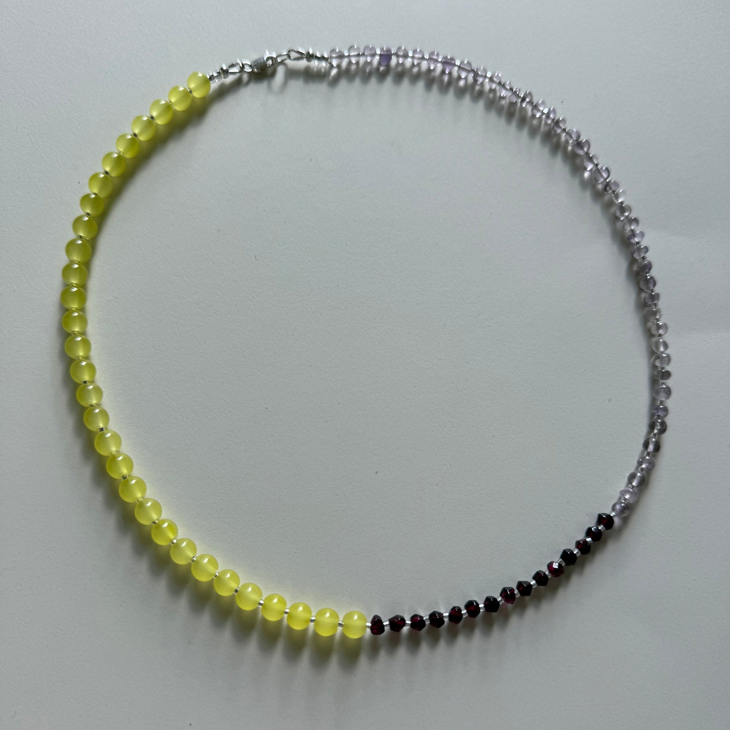 Necklace with yellow, black, and silver beads on a white background