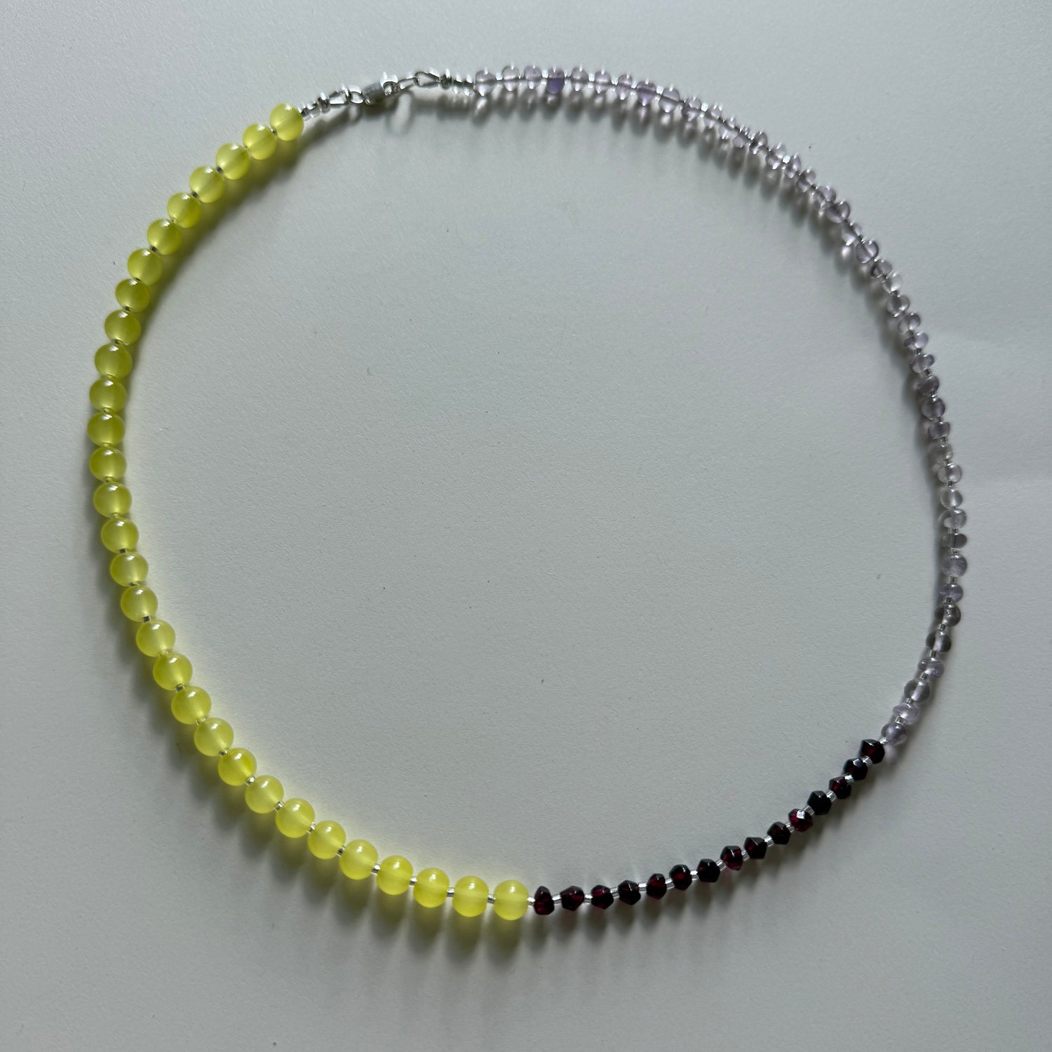 Necklace with yellow, black, and silver beads on a white background