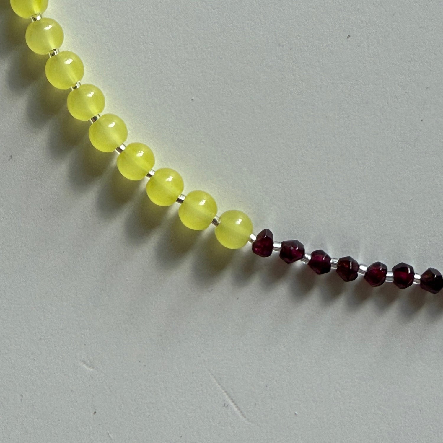 Beaded necklace with yellow and red beads on a gray background