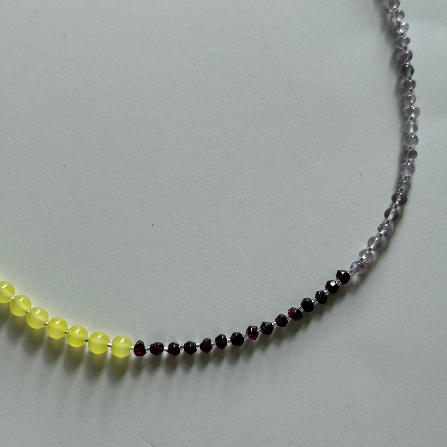 Necklace with multicolored beads on a light gray background
