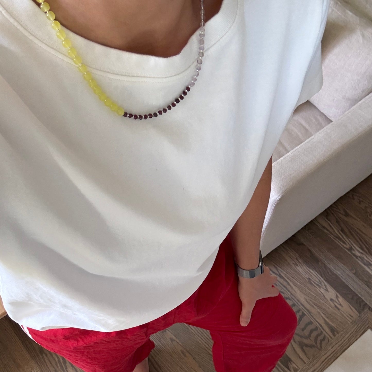 Person wearing a white dress with a red towel on a wooden floor