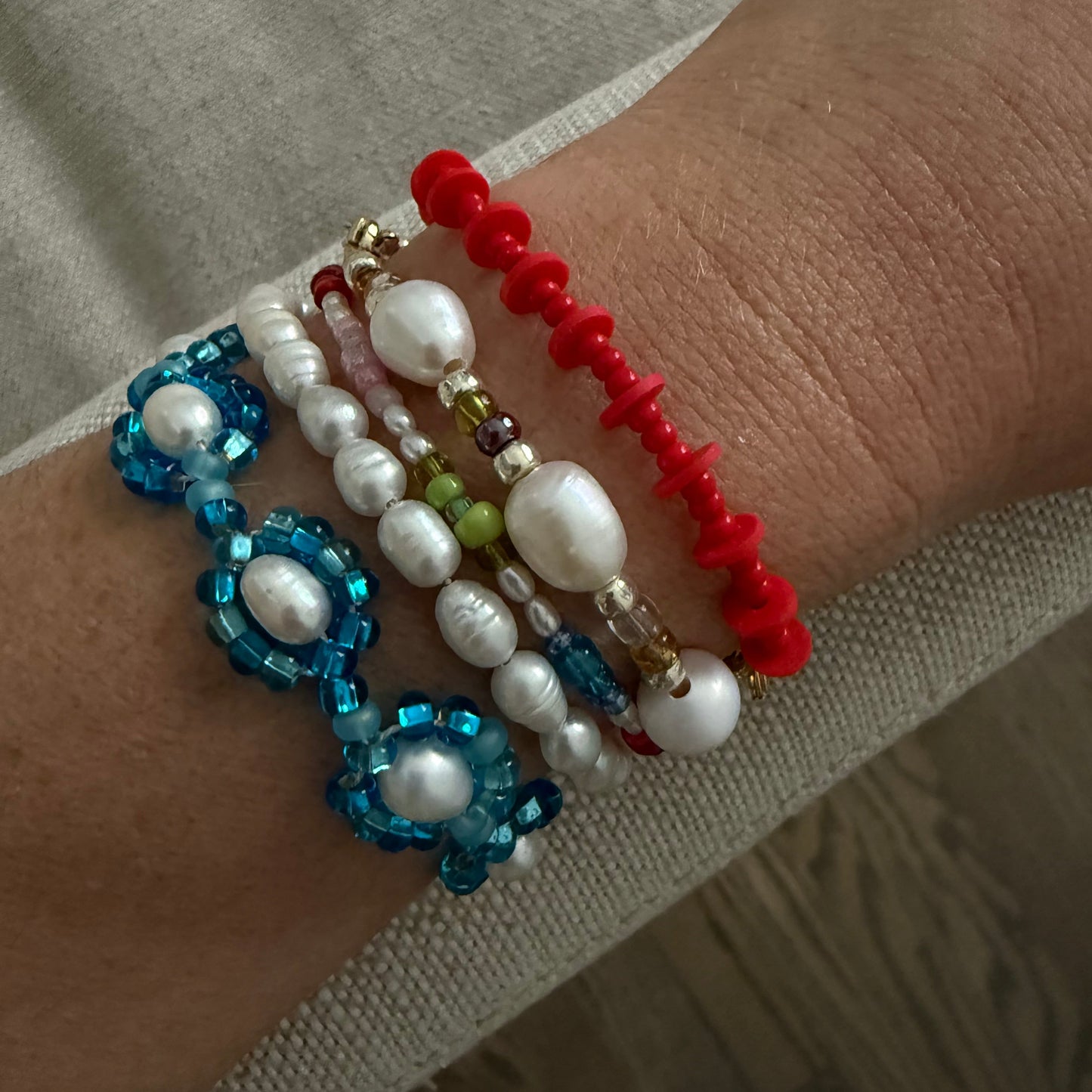 Multicolored beaded bracelets on a wrist with a neutral background