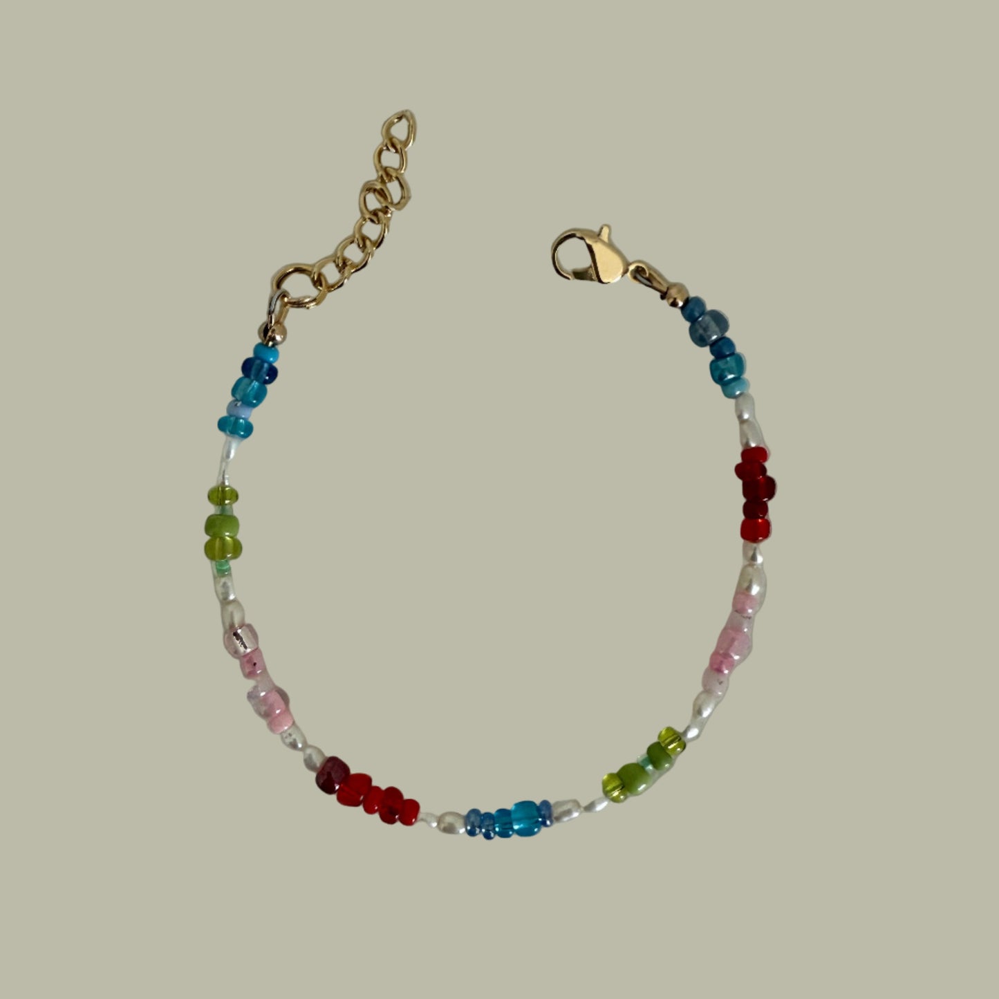 A multicolored beaded bracelet with a gold-filled closure, featuring a combination of Japanese seed beads and freshwater pearls.
