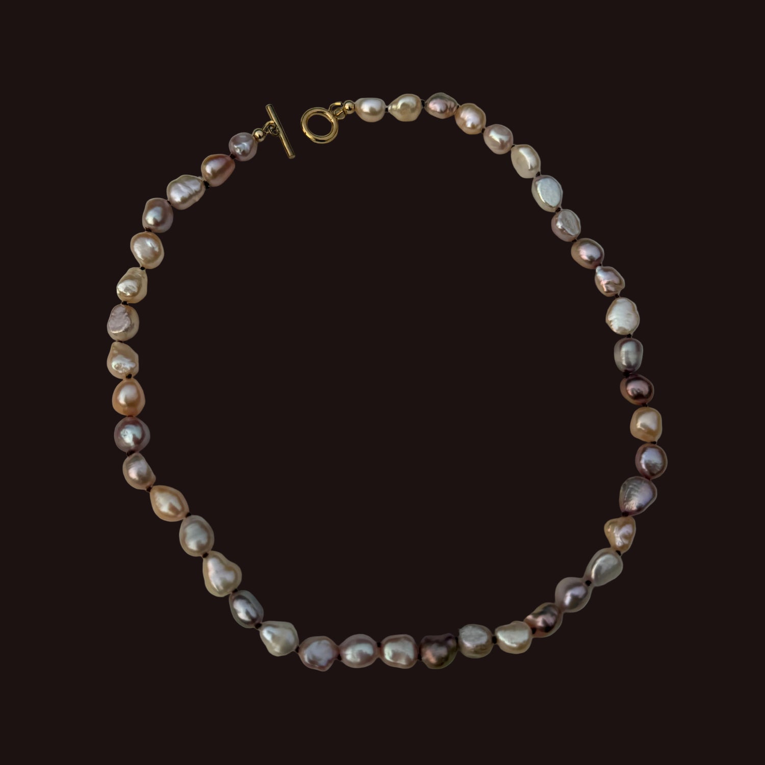 A baroque pearl necklace with a gold toggle clasp, displayed on a light gray background.