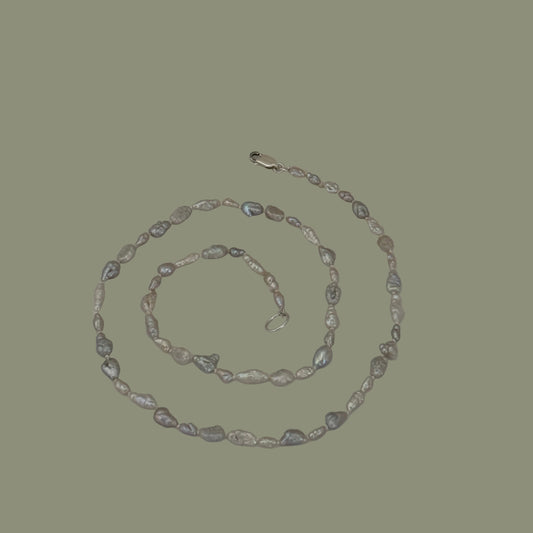 Pearl necklace on a light gray background