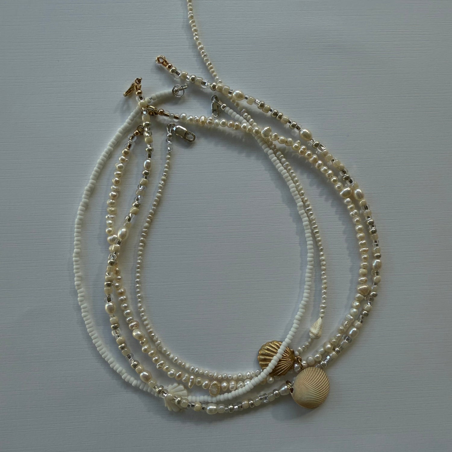 Set of gold necklaces on a light gray background