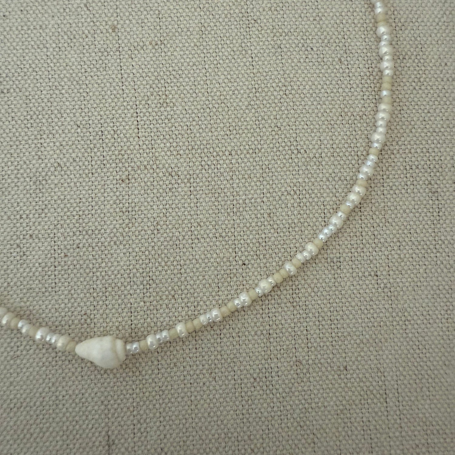 Pearl necklace on a textured beige background