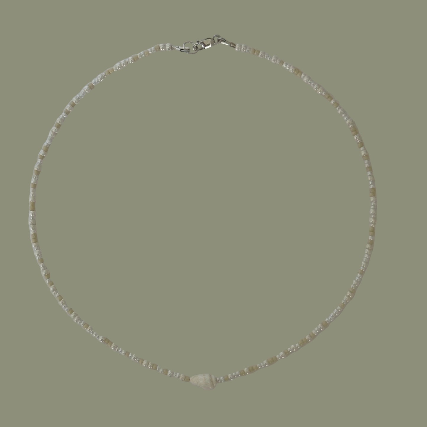 Necklace with small beads on a light gray background