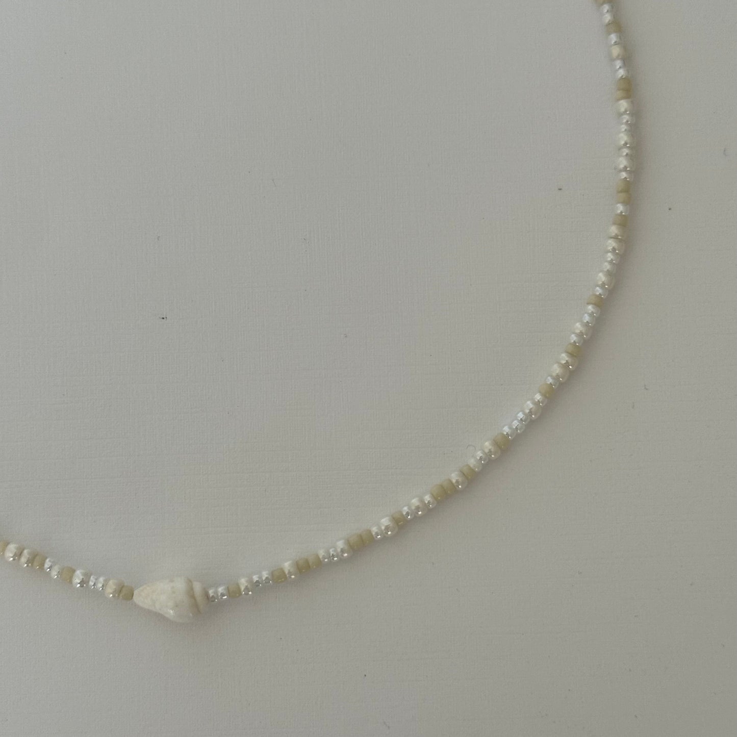 Necklace with small beads on a light gray background