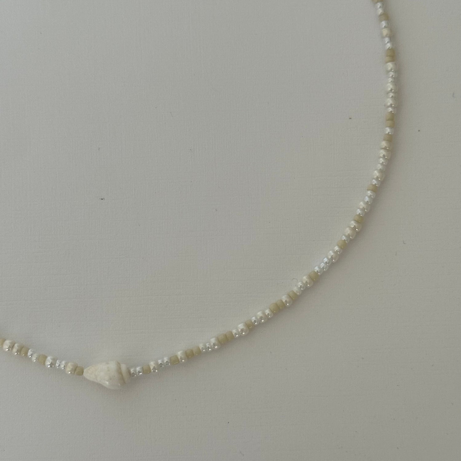 Necklace with small beads on a light gray background