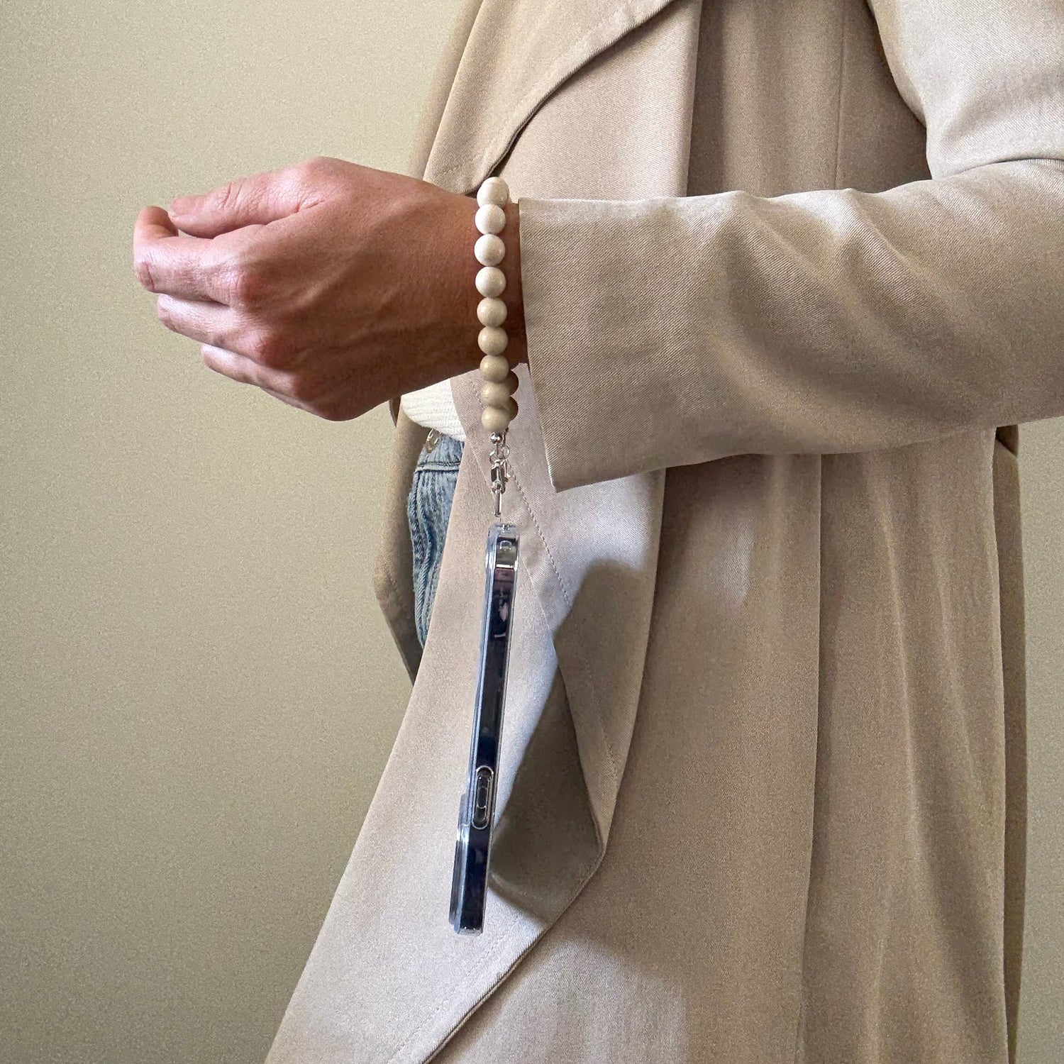 Person wearing a beaded fossil jasper phone chain.