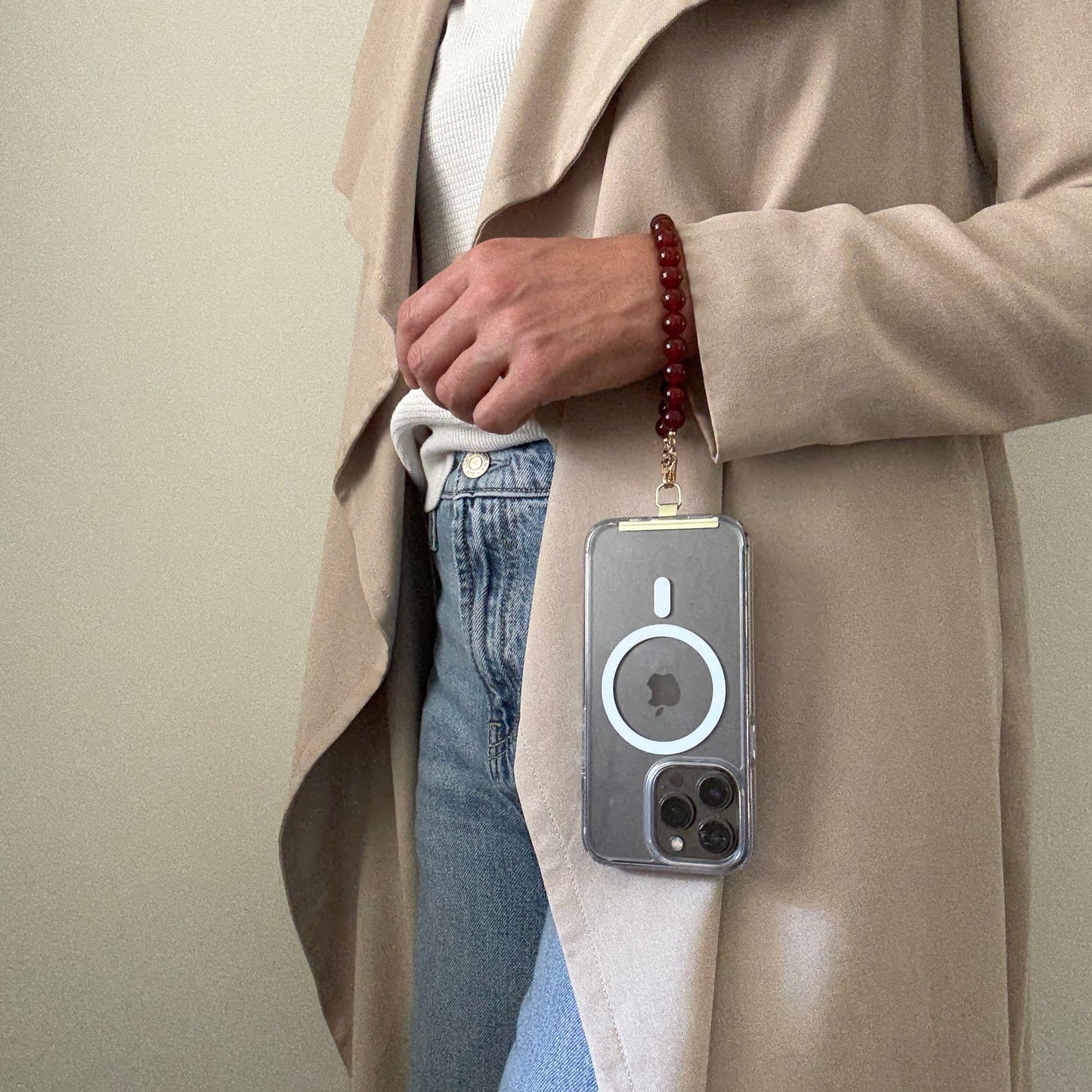 Person holding a phone with a carnelian phone chain