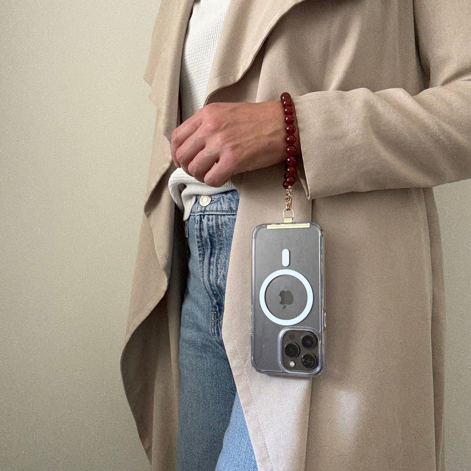Person holding a phone with a carnelian phone chain