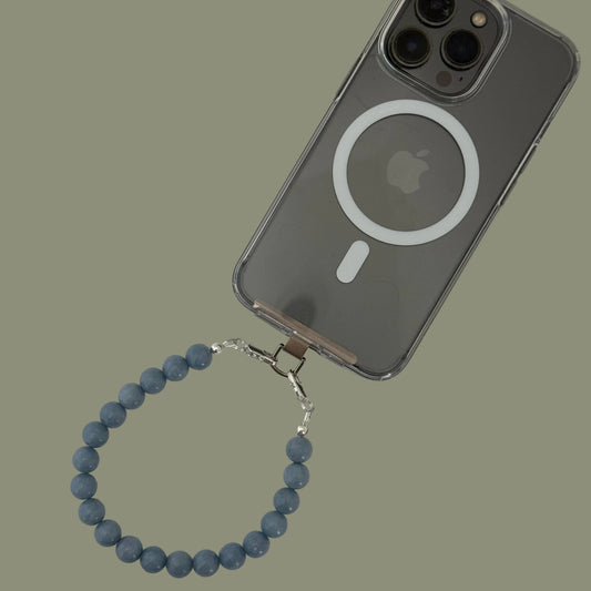 Smartphone with a blue beaded phone chain on a light gray background