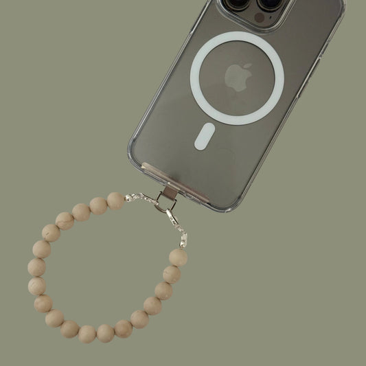 Smartphone with clear case and a beaded beige phone chain on a white background