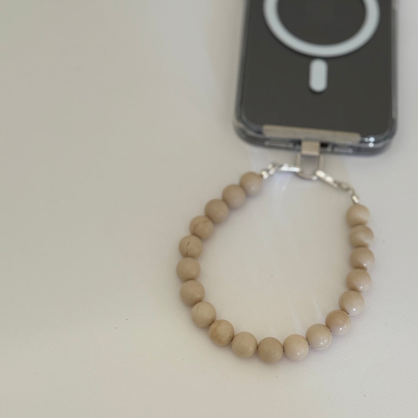 Beaded keychain attached to a phone case on a white surface