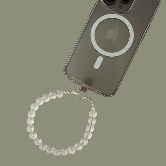 Smartphone with clear quartz beaded phone chain on a light gray background