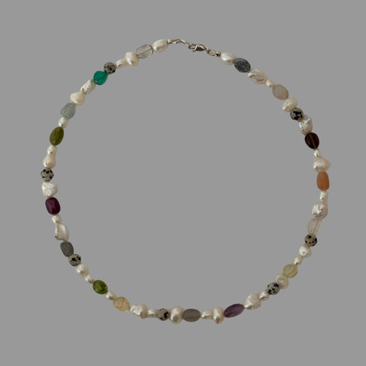 Necklace with multicolored beads on a light gray background