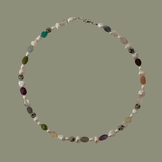 Necklace with multicolored beads on a light gray background