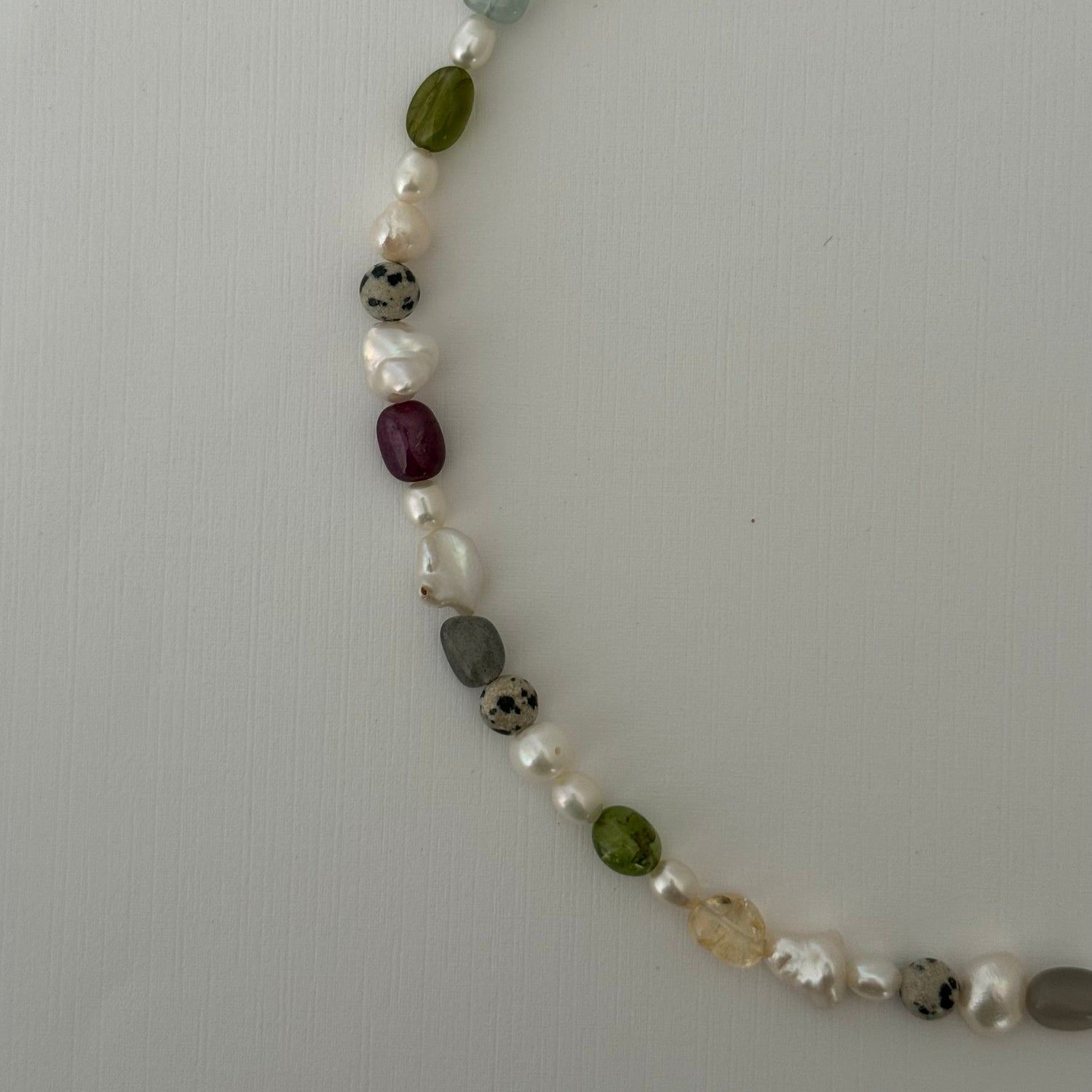 Necklace with multicolored beads on a light gray background
