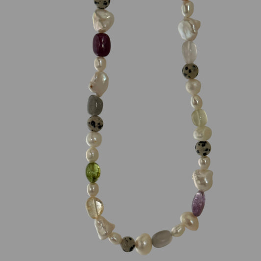 Necklace with multicolored beads on a plain background