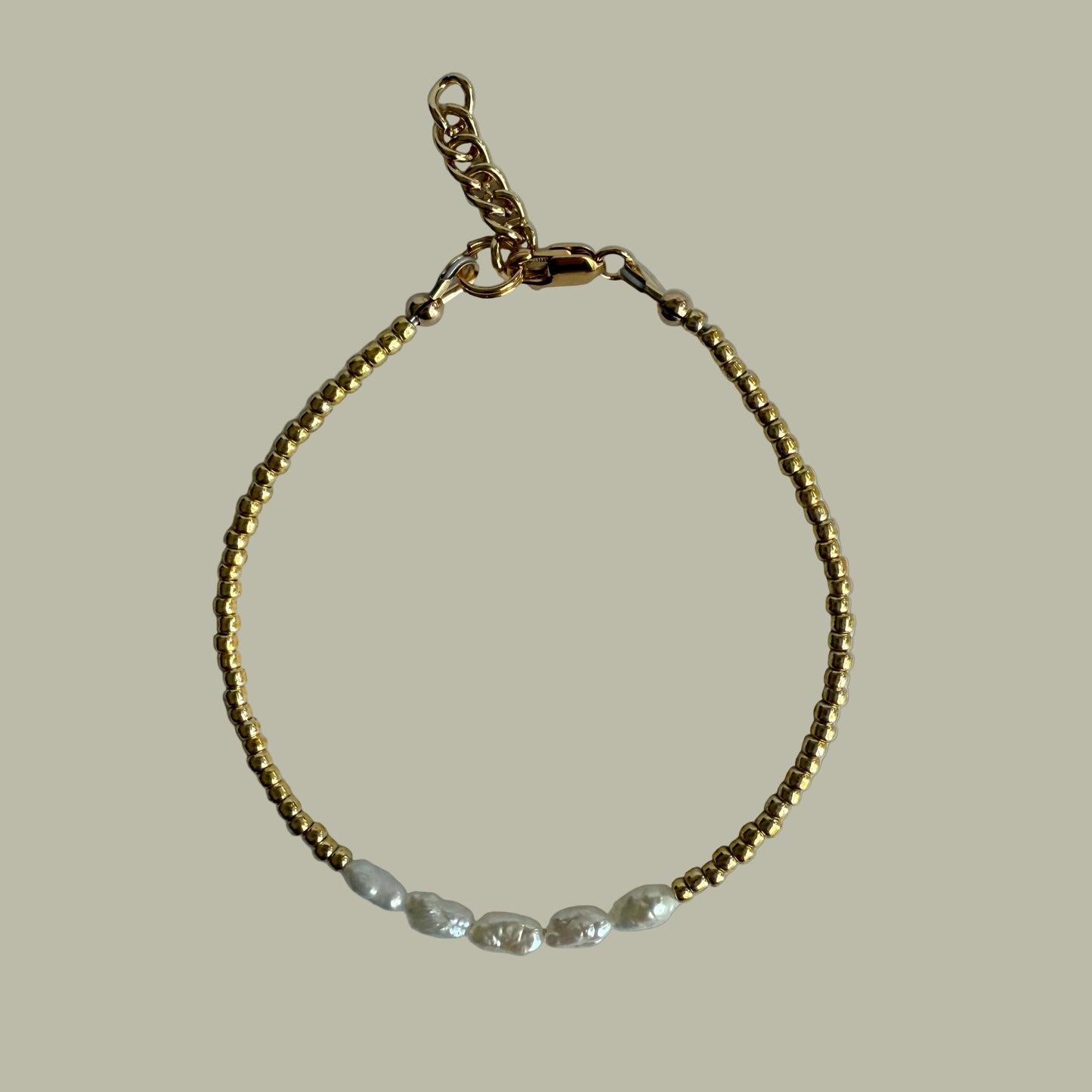 Gold bracelet on a light gray background