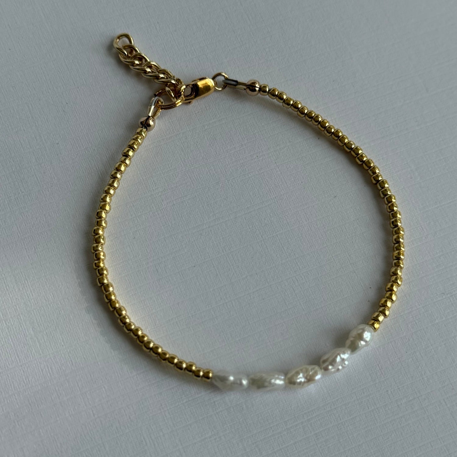 Gold bracelet with a chain link design on a light gray background