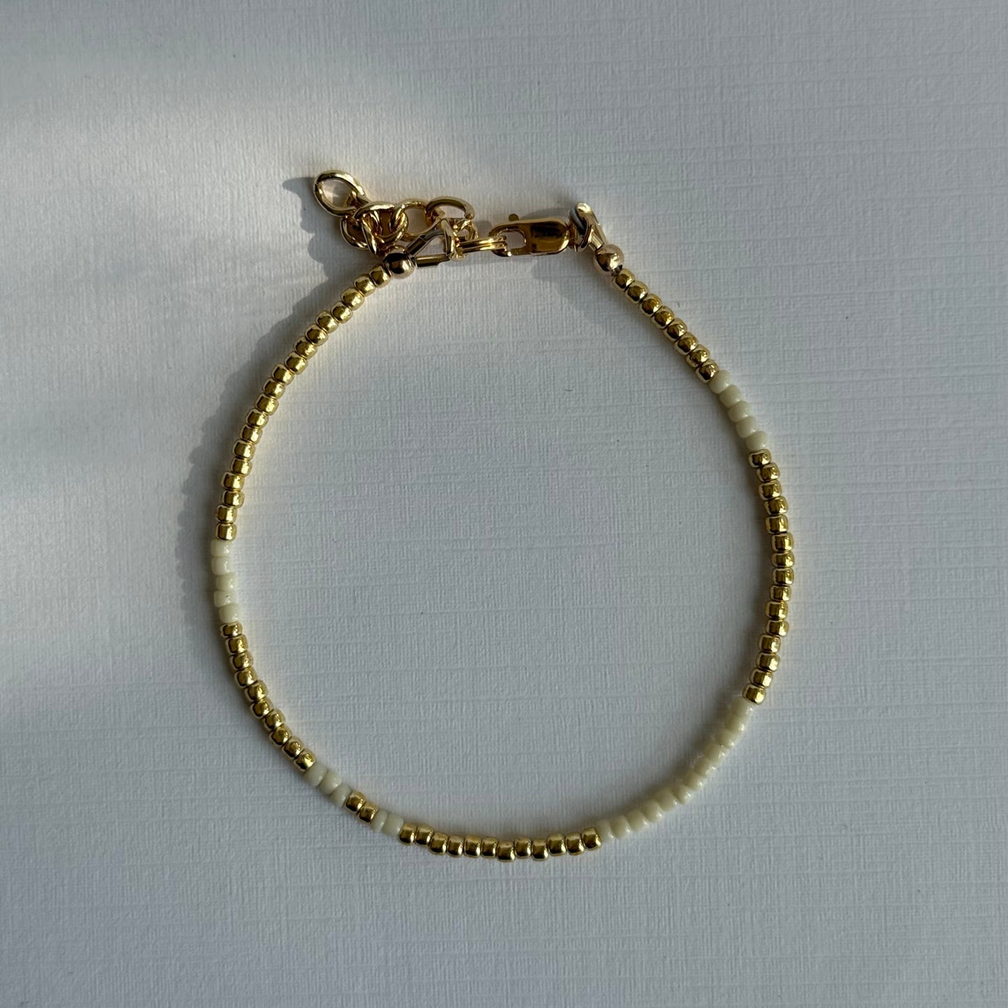 Gold bracelet on a light gray background