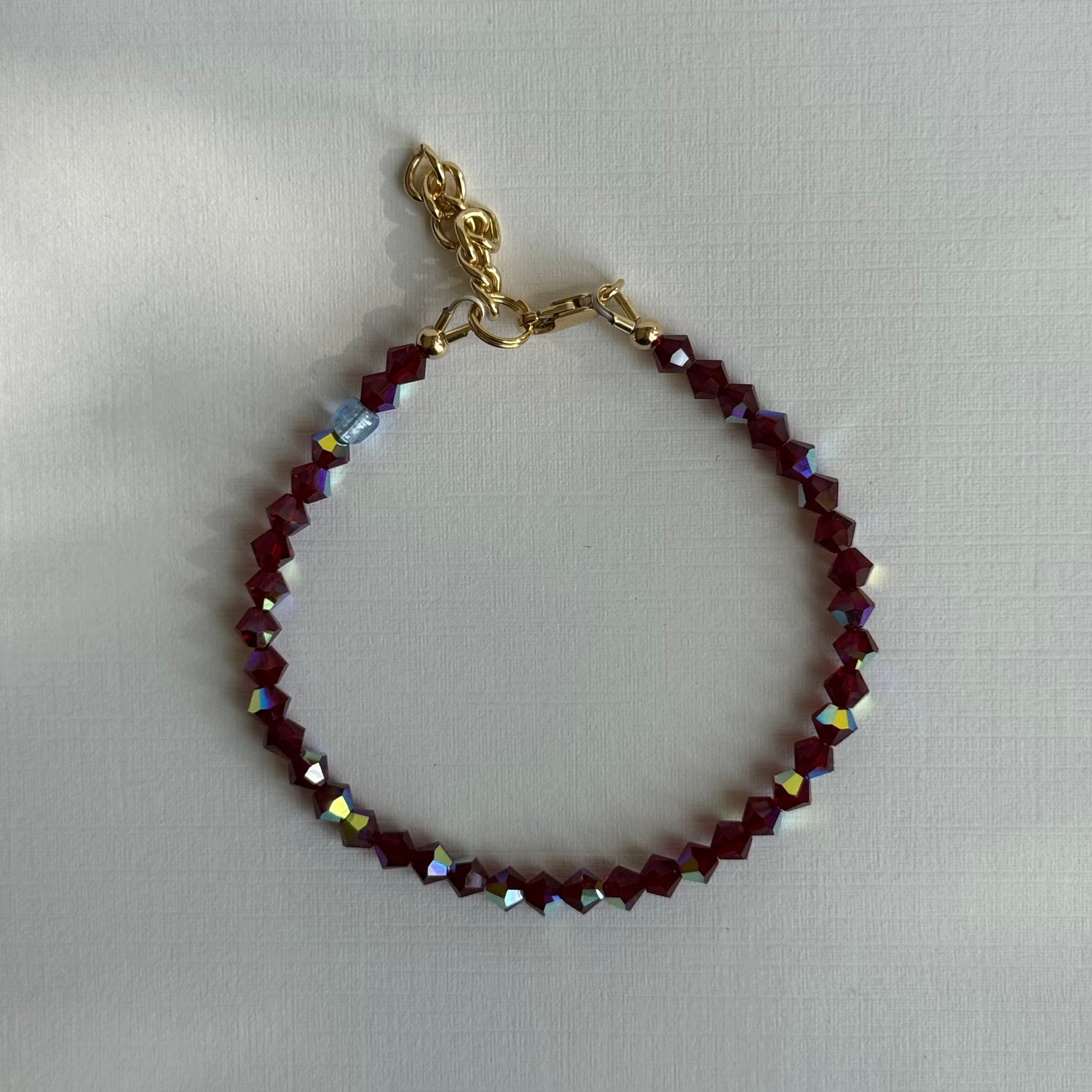 Beaded bracelet with gold clasp on a light gray background