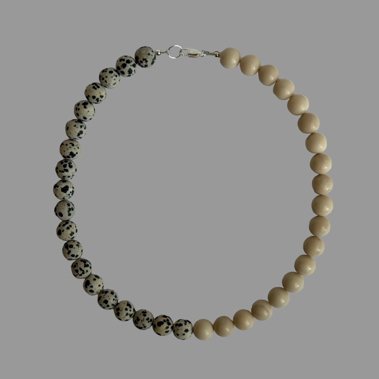 Necklace with alternating black and white beads on a light gray background