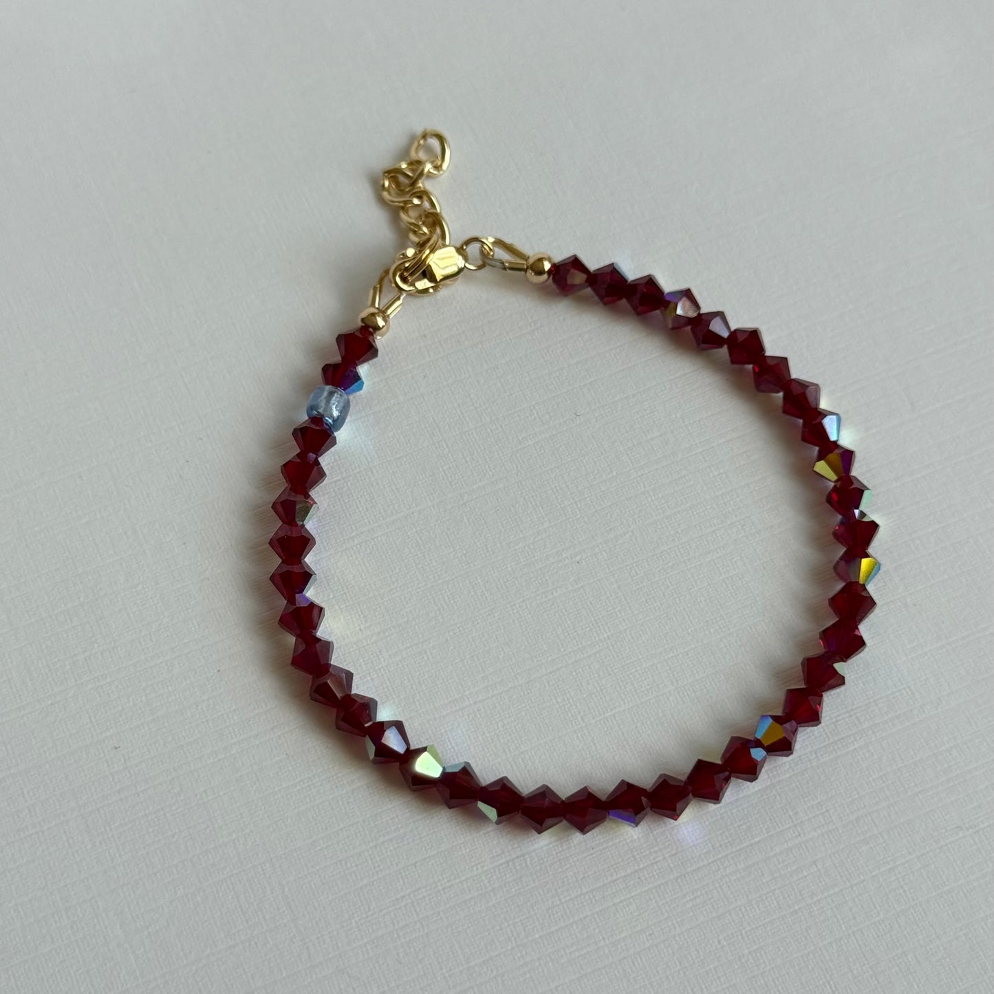 Beaded bracelet with gold clasp on a light gray background