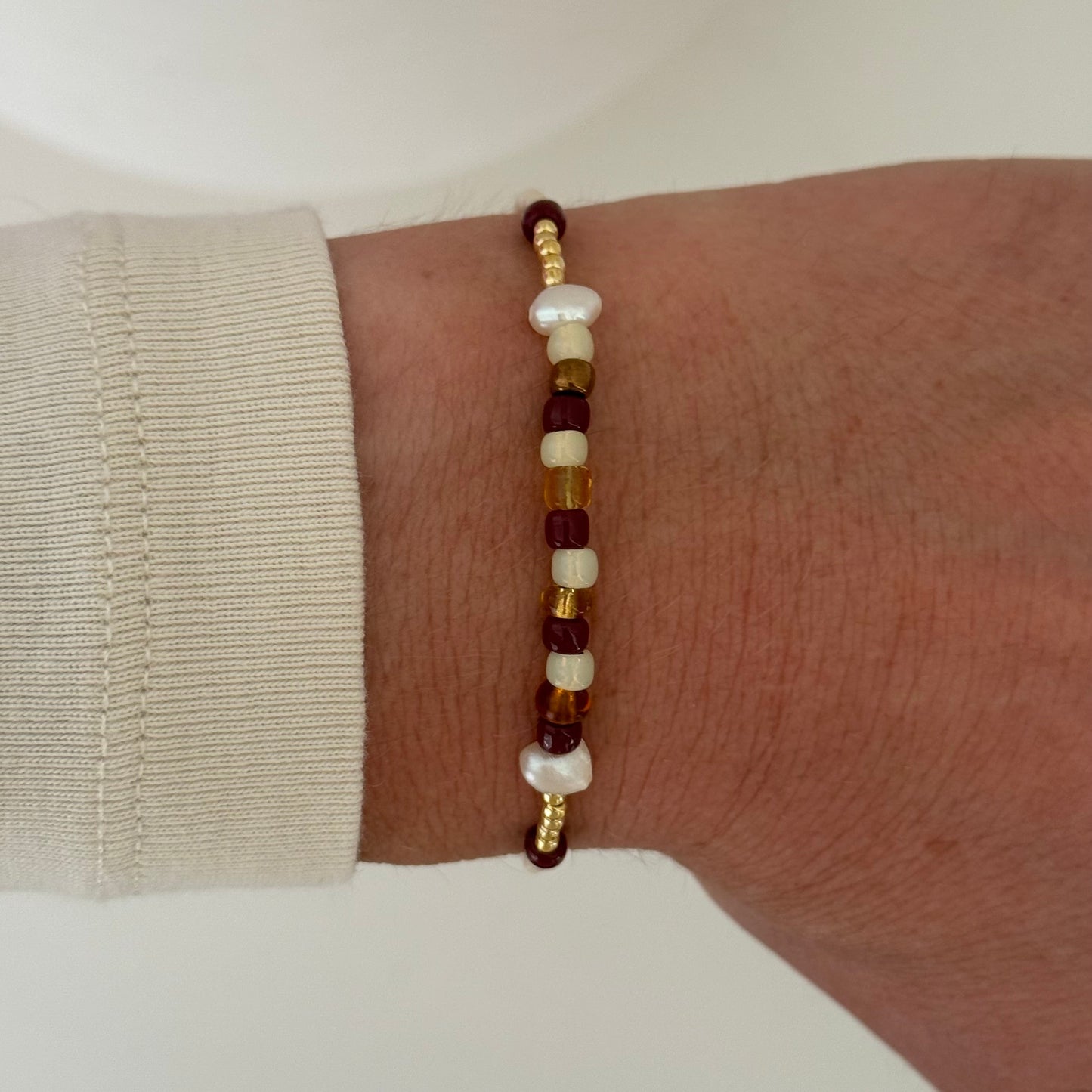 Beaded bracelet on a wrist with a neutral background