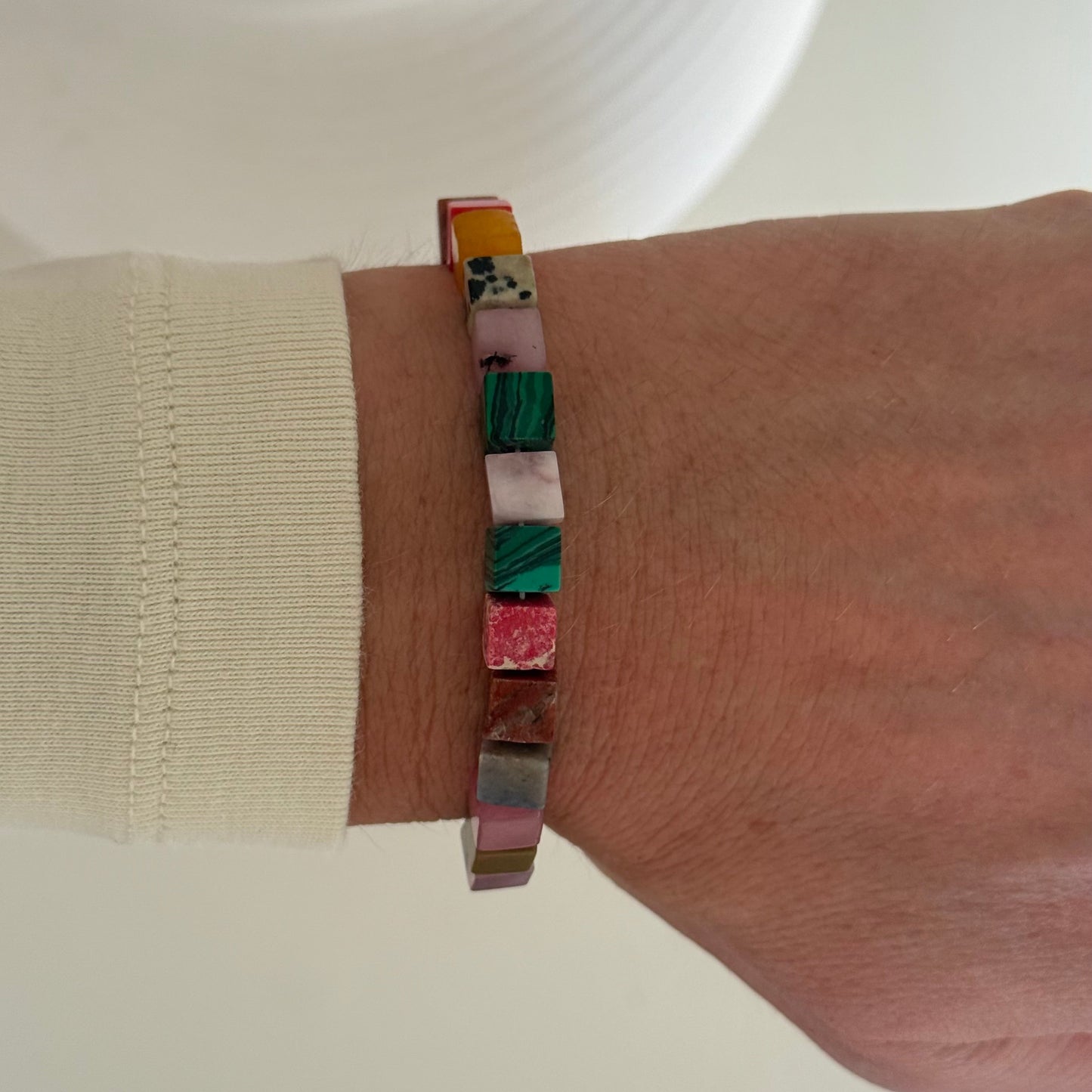 Colorful bracelet on a wrist with a neutral background