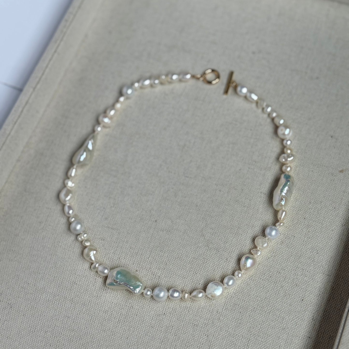 Pearl necklace on a light gray surface