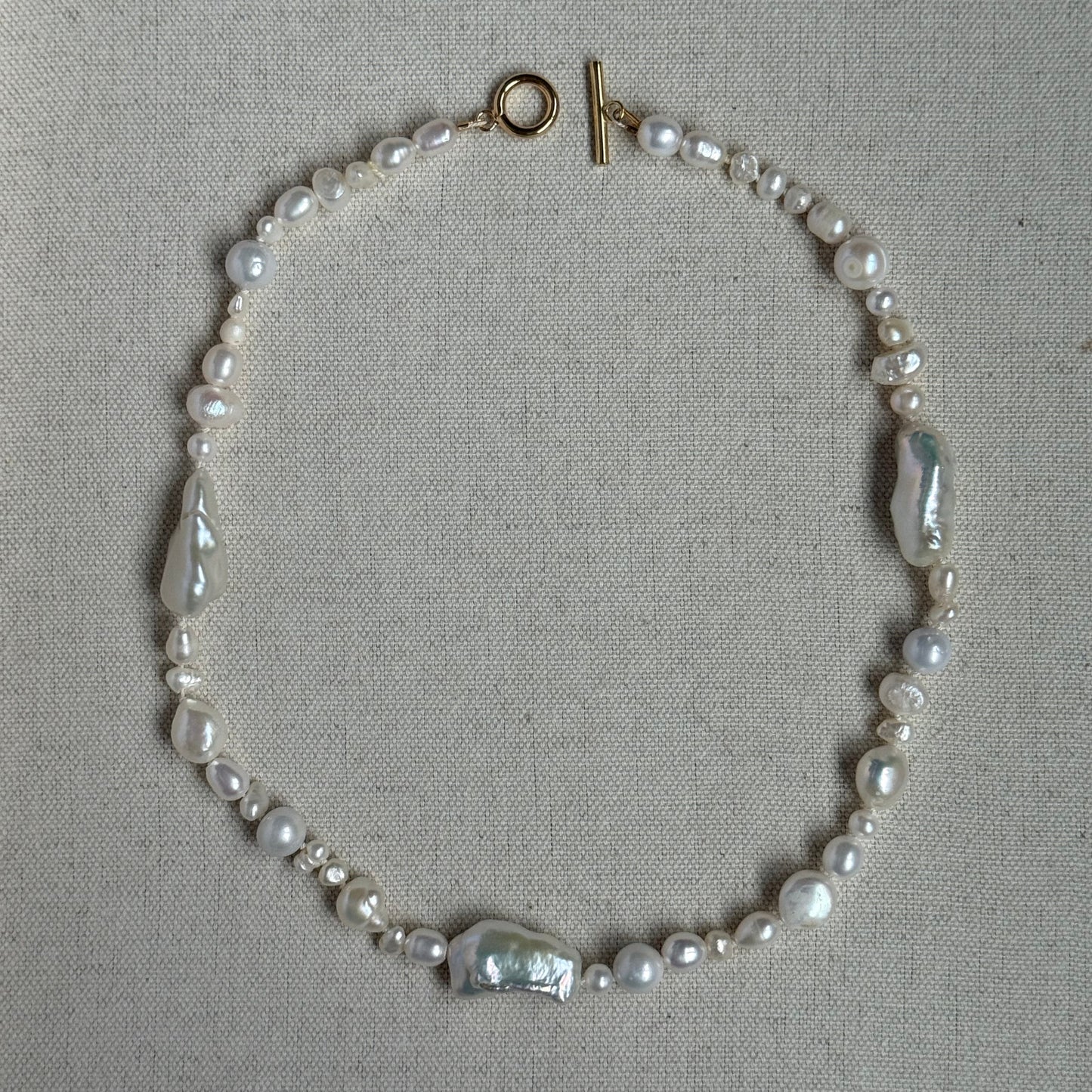 Pearl necklace on a gray fabric background