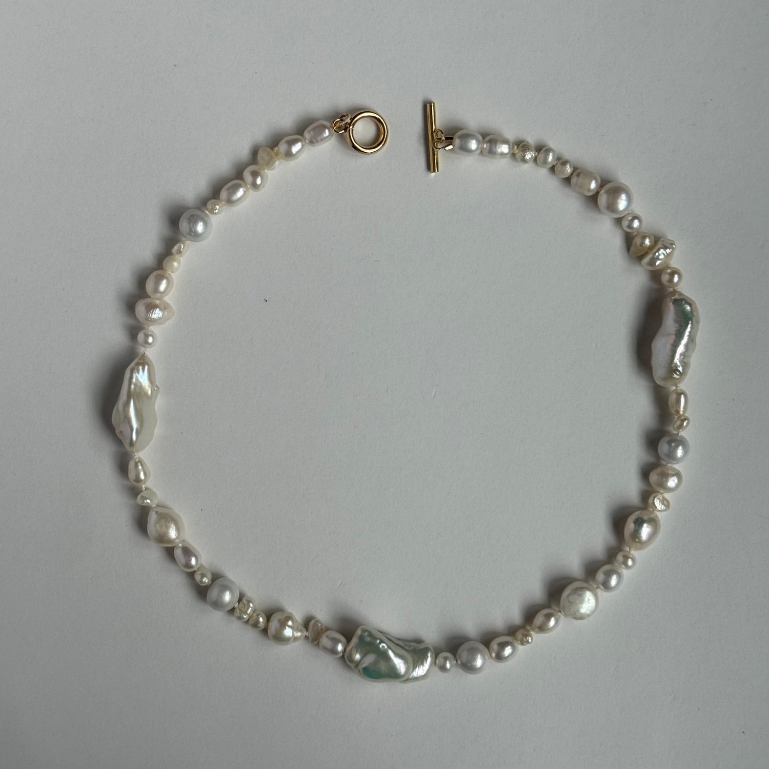 Pearl bracelet with a clasp on a light gray background